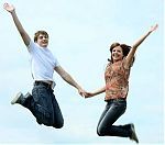 Young happy couple jumping and holding hands.